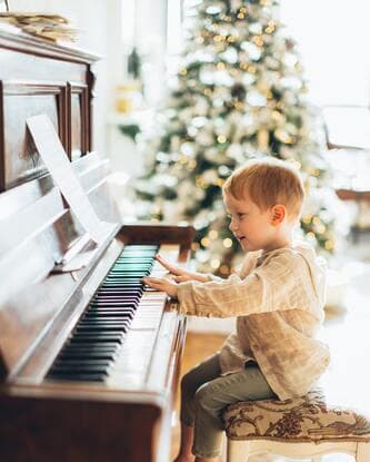 Un jeune enfant joue sur un piano droit